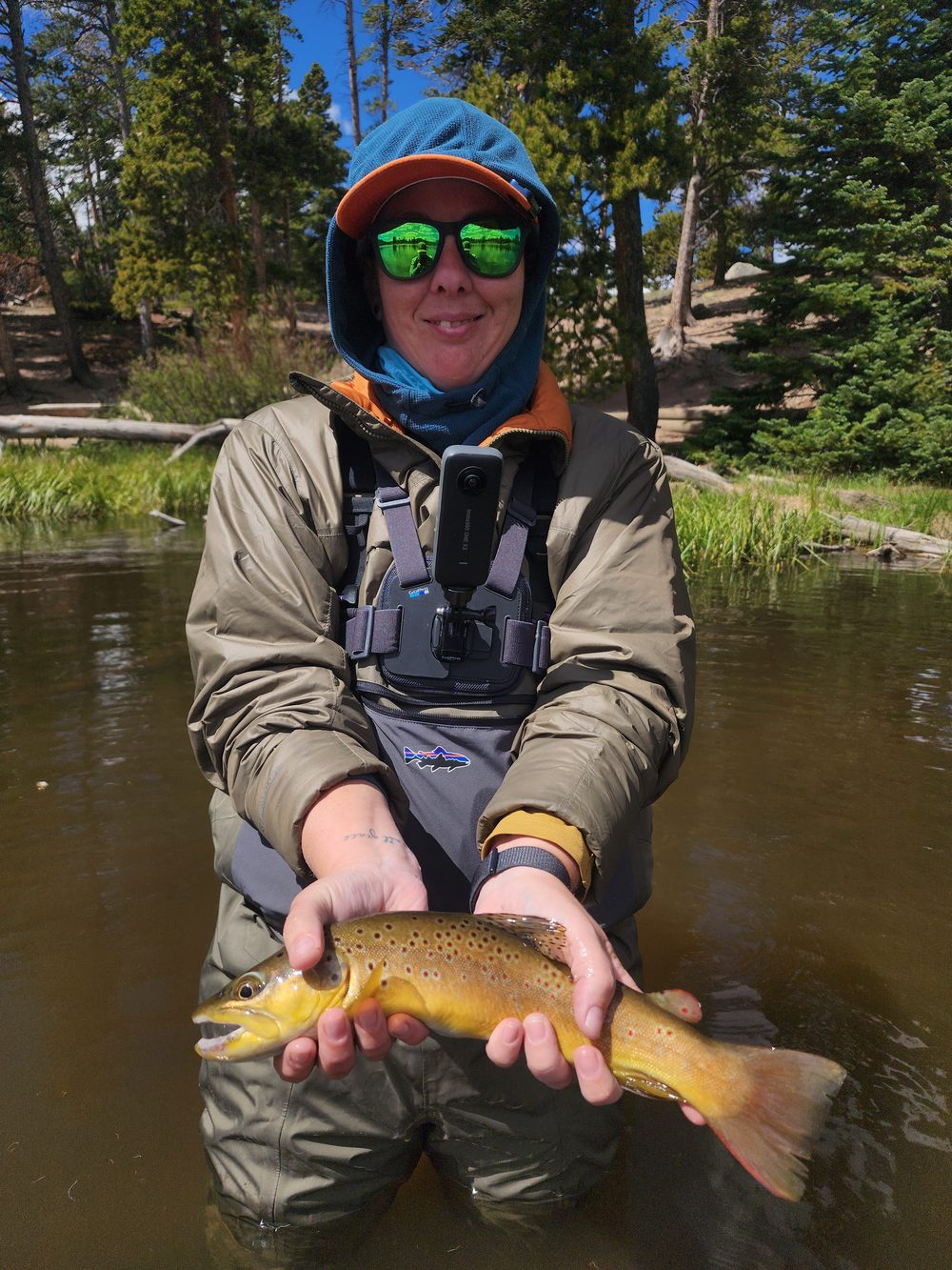 Niki Mosier, founder of Confidence Fly Search, holding a brown trout caught while fly fishing in Colorado